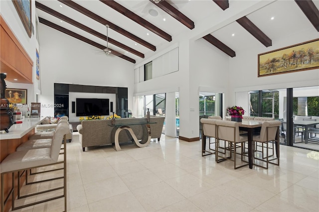 living room featuring beam ceiling, ceiling fan, and high vaulted ceiling