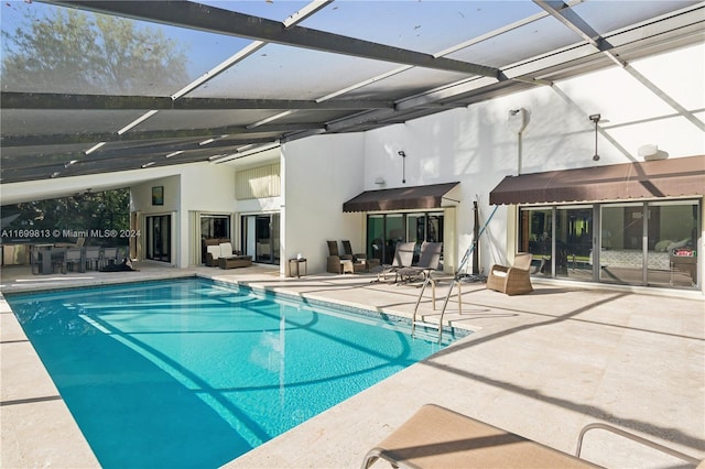 view of swimming pool featuring glass enclosure and a patio area