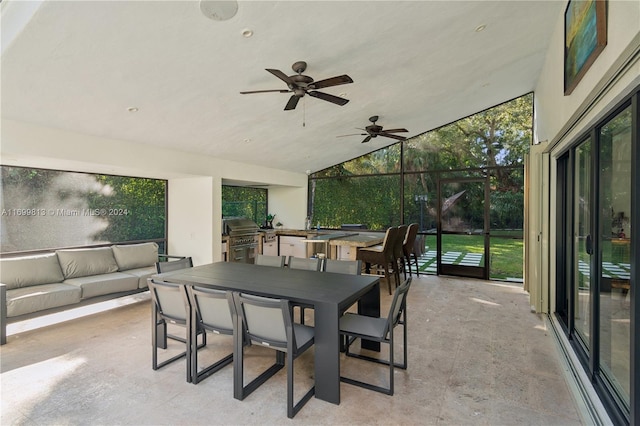 view of patio with ceiling fan, area for grilling, glass enclosure, and an outdoor kitchen