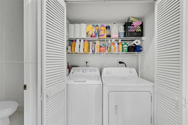 clothes washing area with tile patterned flooring, a textured ceiling, and washer and clothes dryer