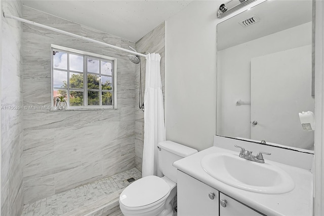 bathroom featuring vanity, toilet, and curtained shower