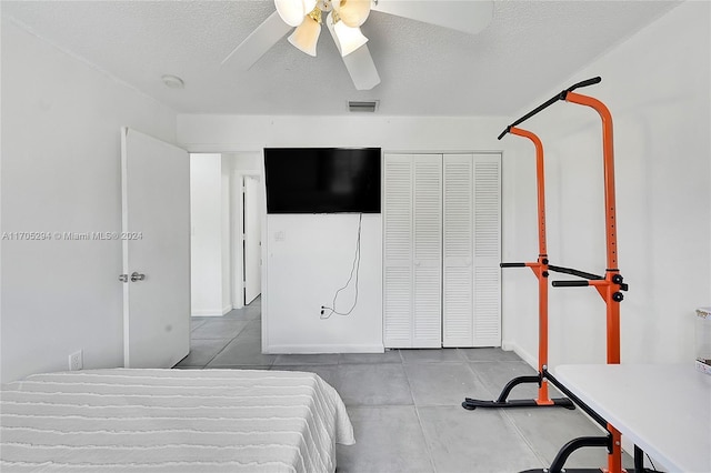 bedroom with ceiling fan, a closet, and a textured ceiling