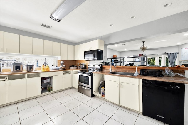 kitchen featuring light tile patterned floors, sink, backsplash, and black appliances