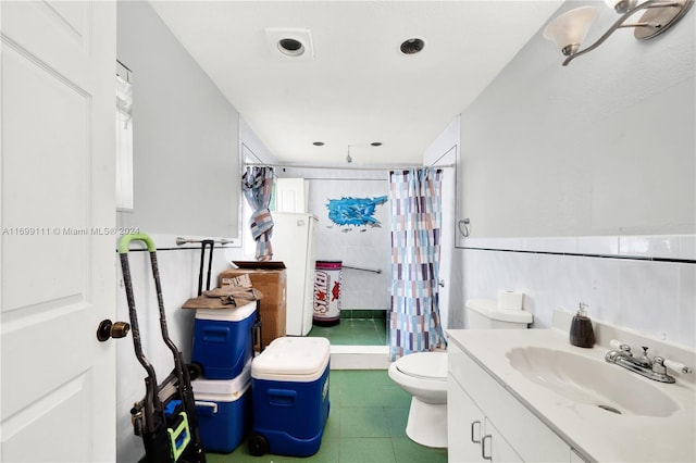 bathroom with tile patterned floors, toilet, vanity, tile walls, and a shower with shower curtain