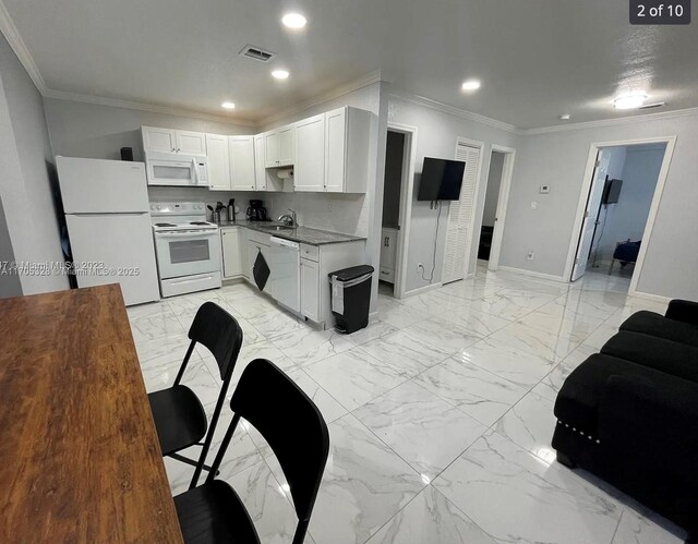 kitchen with white cabinets, white appliances, crown molding, and sink