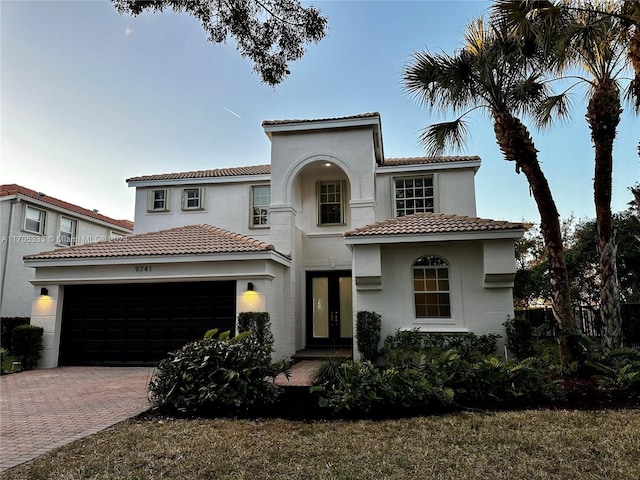 mediterranean / spanish house with french doors and a garage