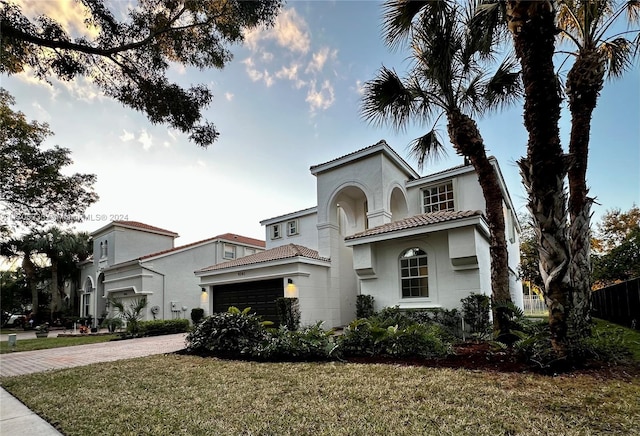 mediterranean / spanish-style house with a garage and a yard