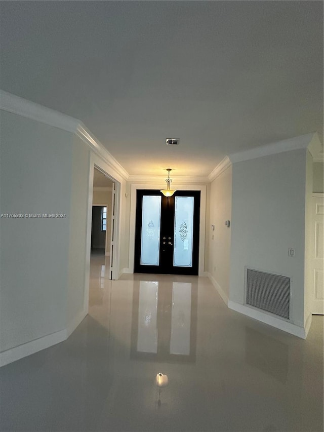 entrance foyer with crown molding and french doors