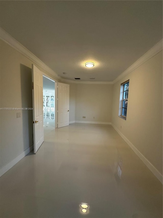 empty room featuring a textured ceiling and ornamental molding