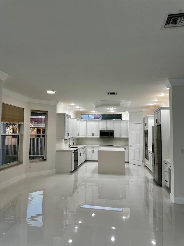 kitchen featuring white cabinets, ornamental molding, sink, and appliances with stainless steel finishes