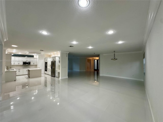 interior space featuring light tile patterned flooring, ornamental molding, and sink