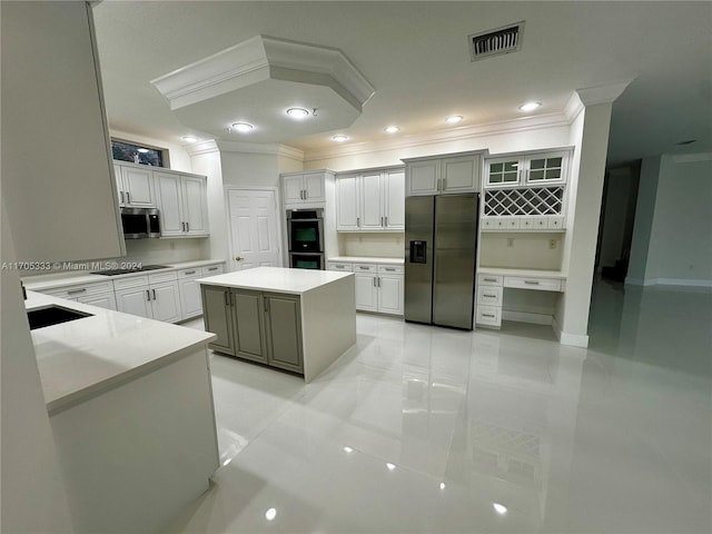 kitchen with a center island, light tile patterned floors, crown molding, and appliances with stainless steel finishes