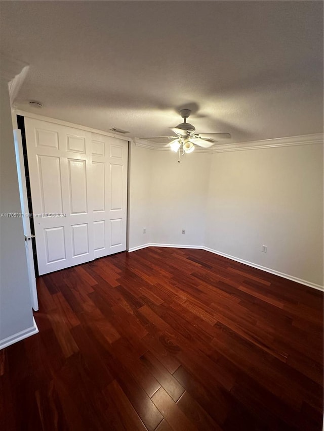 unfurnished bedroom with ceiling fan, dark hardwood / wood-style flooring, crown molding, and a textured ceiling