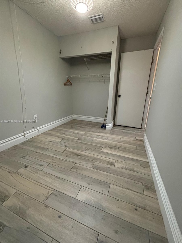 interior space featuring light hardwood / wood-style floors and a textured ceiling