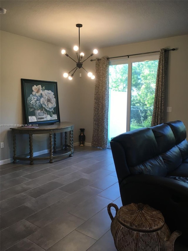 living area with a chandelier and baseboards