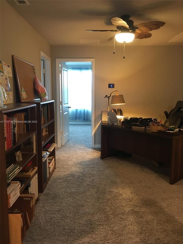 home office featuring carpet floors, visible vents, and ceiling fan