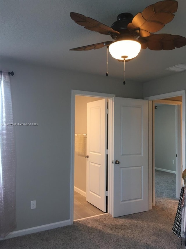 unfurnished bedroom with a ceiling fan, baseboards, visible vents, and carpet flooring