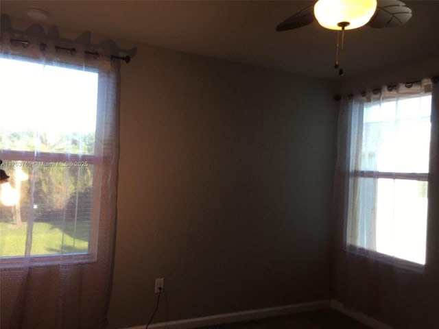 unfurnished room featuring a ceiling fan and a healthy amount of sunlight