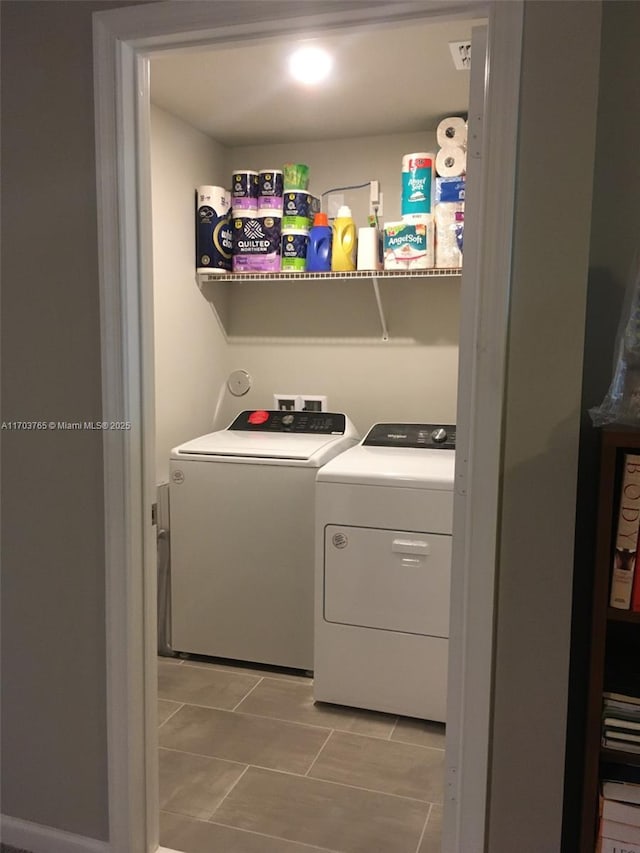 laundry room with laundry area, independent washer and dryer, and light tile patterned flooring