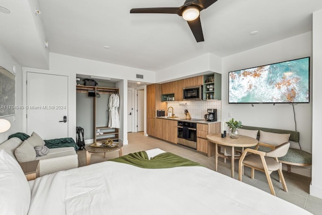 tiled bedroom featuring ceiling fan, a closet, and sink