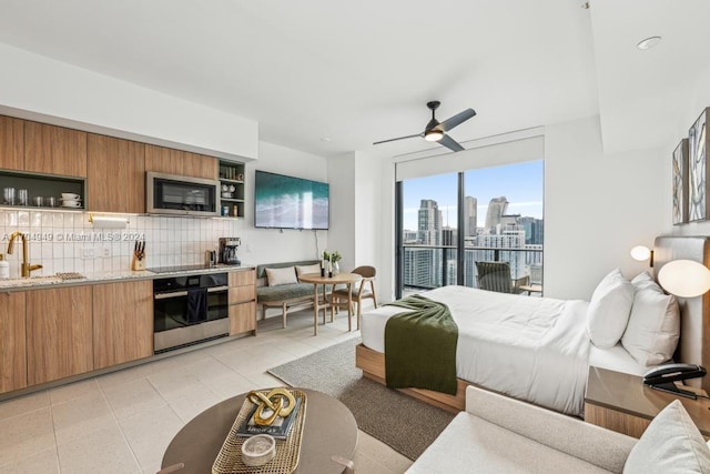 bedroom with access to exterior, ceiling fan, sink, and light tile patterned floors