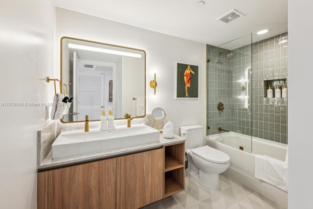 full bathroom with shower / bath combination with glass door, tile patterned floors, vanity, and toilet