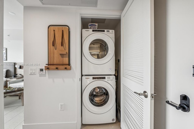 washroom with light tile patterned floors and stacked washer and clothes dryer