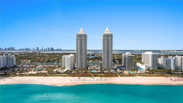 birds eye view of property featuring a water view and a beach view