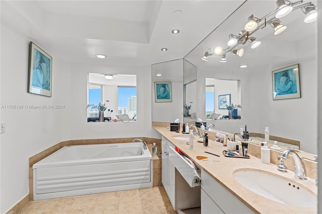 bathroom with vanity, a relaxing tiled tub, and tile patterned floors