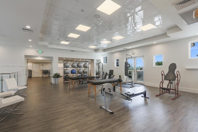 exercise room featuring a paneled ceiling and dark hardwood / wood-style floors