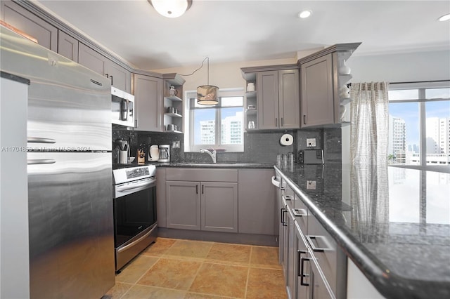 kitchen featuring decorative backsplash, plenty of natural light, stainless steel appliances, and decorative light fixtures