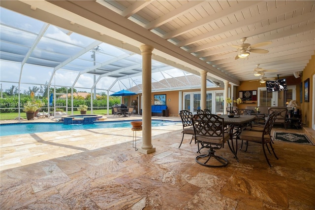 view of swimming pool with ceiling fan, a patio area, a lanai, and an in ground hot tub