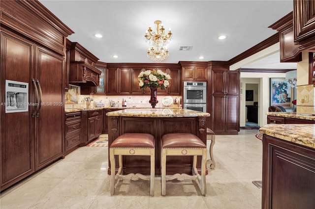 7720 SW 183rd Ter, Palmetto Bay, FL 33157 - kitchen featuring light stone counters, a center island, hanging light fixtures, stainless steel double oven, and backsplash