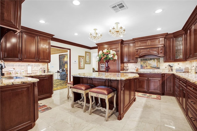 7720 SW 183rd Ter, Palmetto Bay, FL 33157 - kitchen featuring light stone counters, sink, backsplash, and a kitchen island