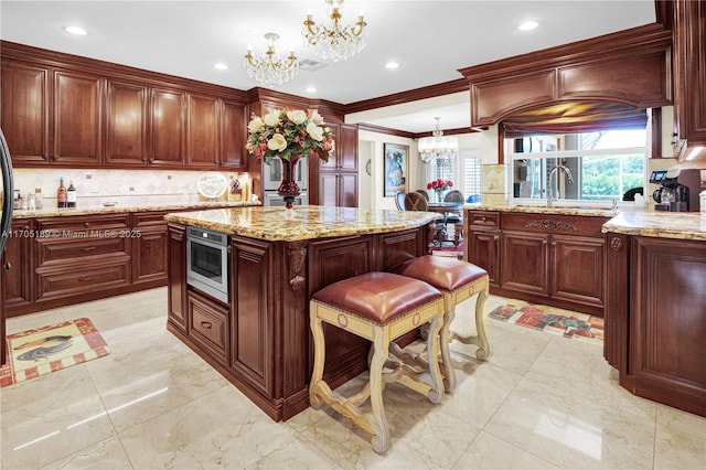 7720 SW 183rd Ter, Palmetto Bay, FL 33157 - kitchen featuring pendant lighting, stainless steel microwave, a center island, and sink