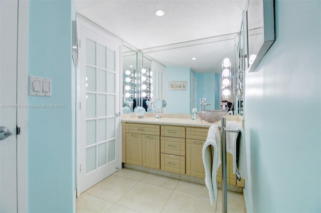 bathroom featuring vanity, tile patterned floors, and a textured ceiling