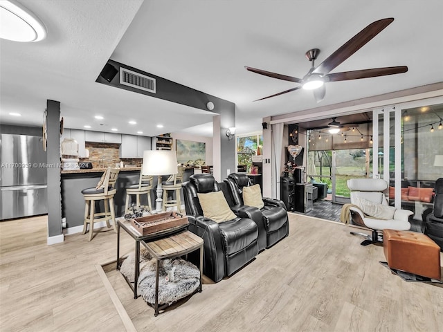 living room with ceiling fan and light hardwood / wood-style flooring