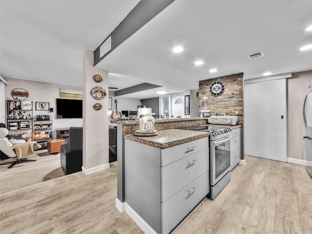 kitchen with stone countertops, a kitchen island, light wood-type flooring, and stainless steel electric range oven