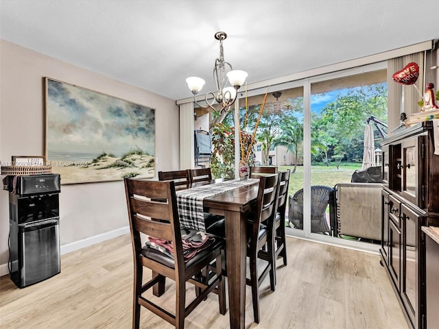 dining space featuring a notable chandelier and light hardwood / wood-style flooring