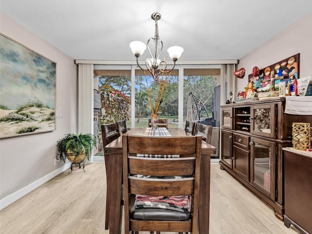 dining room with expansive windows, light hardwood / wood-style floors, and a notable chandelier