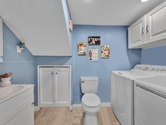 laundry area featuring light wood-type flooring, independent washer and dryer, and sink