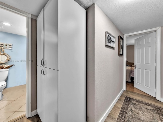 corridor featuring hardwood / wood-style floors and a textured ceiling