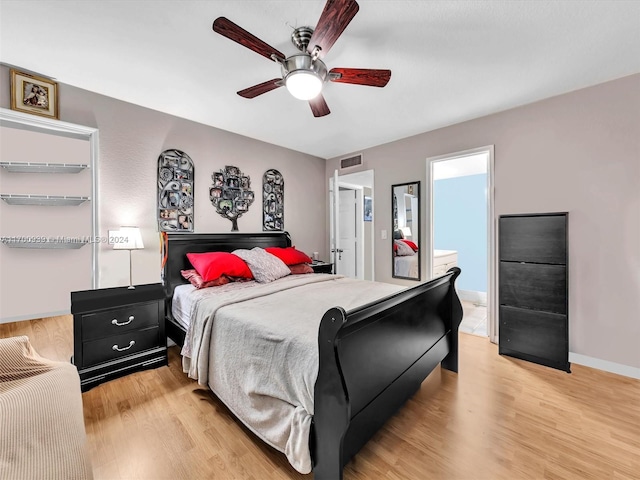 bedroom with ceiling fan, light wood-type flooring, and ensuite bathroom