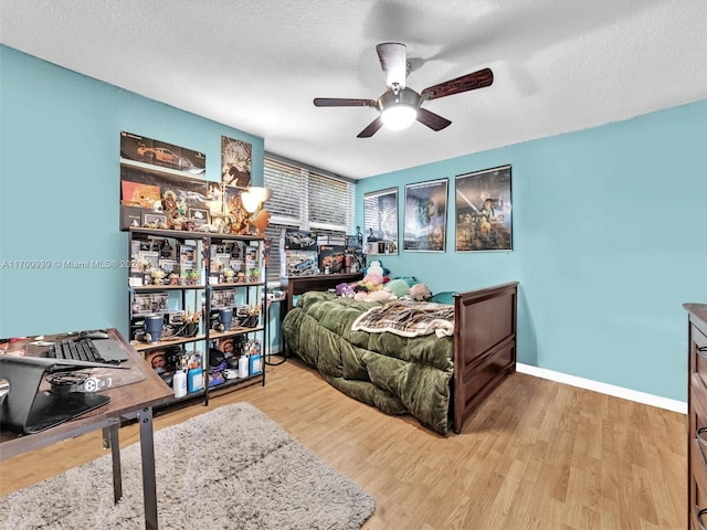 bedroom with ceiling fan, a textured ceiling, and light hardwood / wood-style flooring