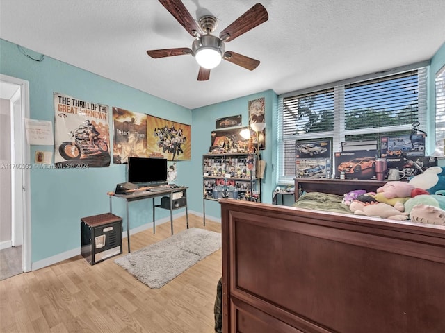 bedroom with a textured ceiling, light hardwood / wood-style flooring, and ceiling fan