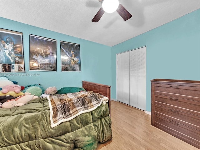 bedroom with ceiling fan, a closet, a textured ceiling, and light wood-type flooring