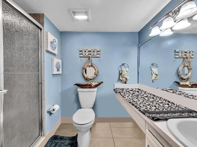 bathroom featuring tile patterned floors, vanity, an enclosed shower, and toilet