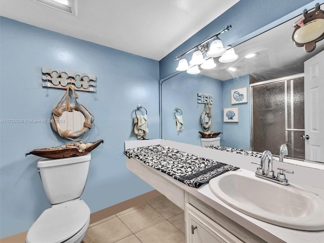 bathroom with toilet, tile patterned flooring, vanity, and walk in shower