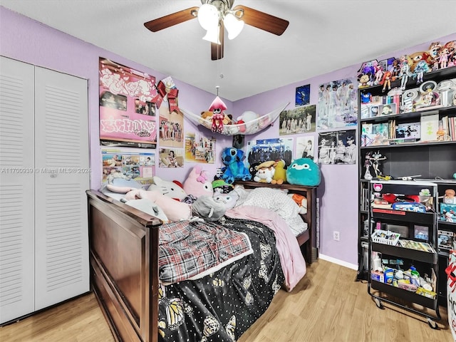 bedroom with ceiling fan, a closet, and light hardwood / wood-style floors