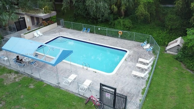 view of pool with a lawn and a patio area